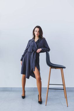 Gri yay ceketli, ince, güzel bir kadın ve zarif yüksek topuklu ayakkabılar. Yeni deri ayakkabı koleksiyonundan siyah ayakkabılı şık bir kız.