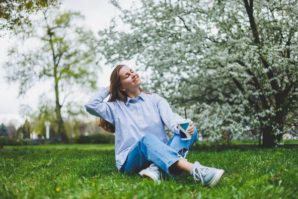 Fiatal Hipszter Farmerdzsekiben Zöld Gyepen Pihen Parkban Kávét Iszik Pihent — Stock Fotó