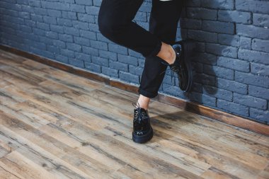 Şık giyinmiş güzel bacakları olan güzel bir kadın, şık, siyah deri, dantelli, yakın plan ayakkabıları olan. Bahar tarzında kadın imajı