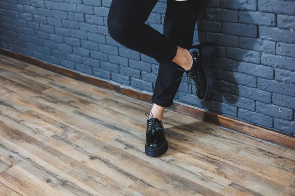 Şık giyinmiş güzel bacakları olan güzel bir kadın, şık, siyah deri, dantelli, yakın plan ayakkabıları olan. Bahar tarzında kadın imajı