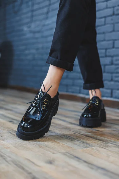 Beautiful woman with legs in fashionable clothes, stylish leather black patent leather lace-up shoes close-up. Womens image in spring style — Stock fotografie