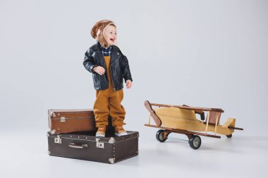 Çocuk deri bir ceket ve pilot şapkası içinde ağlıyordu. Tahta bir uçak, kahverengi bavullar. Çocukların tahta oyuncakları. Bebek duyguları