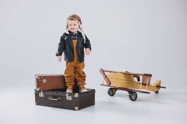 Çocuk deri bir ceket ve pilot şapkası içinde ağlıyordu. Tahta bir uçak, kahverengi bavullar. Çocukların tahta oyuncakları. Bebek duyguları