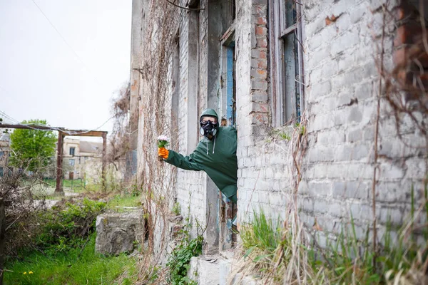 Man Raincoat Gas Mask Collects Flower Scorched Poisonous Earth Air — Zdjęcie stockowe