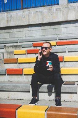 Elinde cep telefonu olan takım elbiseli gülümseyen iş adamının fotoğrafı.