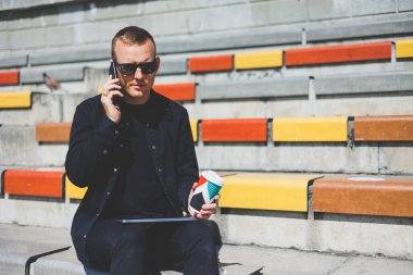 Elinde cep telefonu olan takım elbiseli gülümseyen iş adamının fotoğrafı.