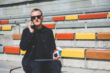 Elinde cep telefonu olan takım elbiseli gülümseyen iş adamının fotoğrafı.