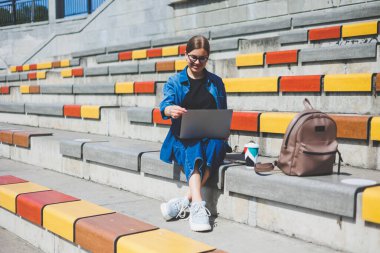 Gözlüklü, optik gözlüklü, kameraya gülümseyen mutlu özgür yazar portresi. Dijital göçebe yaşam tarzının keyfini çıkarıyor. Modern netbook 'lu mutlu bir bilişim uzmanı.