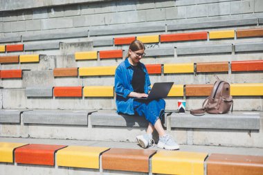 Gözlüklü, optik gözlüklü, kameraya gülümseyen mutlu özgür yazar portresi. Dijital göçebe yaşam tarzının keyfini çıkarıyor. Modern netbook 'lu mutlu bir bilişim uzmanı.