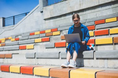Gözlüklü, optik gözlüklü, kameraya gülümseyen mutlu özgür yazar portresi. Dijital göçebe yaşam tarzının keyfini çıkarıyor. Modern netbook 'lu mutlu bir bilişim uzmanı.