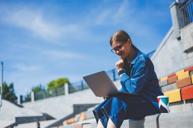 Gözlüklü, optik gözlüklü, kameraya gülümseyen mutlu özgür yazar portresi. Dijital göçebe yaşam tarzının keyfini çıkarıyor. Modern netbook 'lu mutlu bir bilişim uzmanı.