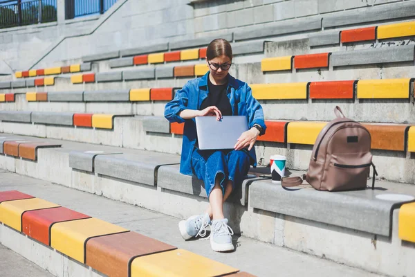 Gözlüklü, optik gözlüklü, kameraya gülümseyen mutlu özgür yazar portresi. Dijital göçebe yaşam tarzının keyfini çıkarıyor. Modern netbook 'lu mutlu bir bilişim uzmanı.