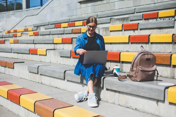 Gözlüklü, optik gözlüklü, kameraya gülümseyen mutlu özgür yazar portresi. Dijital göçebe yaşam tarzının keyfini çıkarıyor. Modern netbook 'lu mutlu bir bilişim uzmanı.