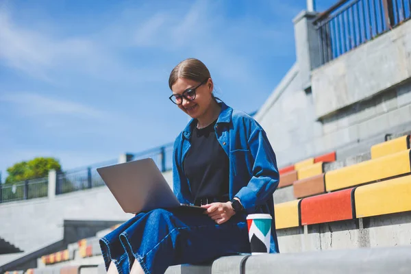 Gözlüklü, optik gözlüklü, kameraya gülümseyen mutlu özgür yazar portresi. Dijital göçebe yaşam tarzının keyfini çıkarıyor. Modern netbook 'lu mutlu bir bilişim uzmanı.