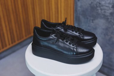 Bağcıklı siyah deri klasik spor ayakkabılar. Sıradan kadın tarzı. Siyah lastik tabanlar. Beyaz arka planda izole edilmiş yakın çekim. Sağ taraf manzaralı. Moda ayakkabıları..