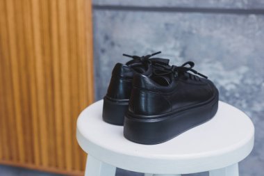 Bağcıklı siyah deri klasik spor ayakkabılar. Sıradan kadın tarzı. Siyah lastik tabanlar. Beyaz arka planda izole edilmiş yakın çekim. Sağ taraf manzaralı. Moda ayakkabıları..