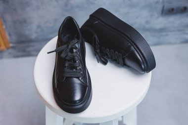 Bağcıklı siyah deri klasik spor ayakkabılar. Sıradan kadın tarzı. Siyah lastik tabanlar. Beyaz arka planda izole edilmiş yakın çekim. Sağ taraf manzaralı. Moda ayakkabıları..