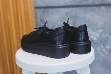 Bağcıklı siyah deri klasik spor ayakkabılar. Sıradan kadın tarzı. Siyah lastik tabanlar. Beyaz arka planda izole edilmiş yakın çekim. Sağ taraf manzaralı. Moda ayakkabıları..