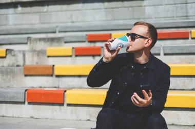 Elinde cep telefonu olan takım elbiseli gülümseyen iş adamının fotoğrafı.