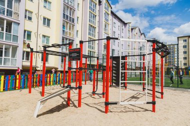 Yüksek katlı yeni binalar. Yeni bir alanda balkonlu daireler. Modern konut binaları. Konut binasının avlusunda spor sahası.