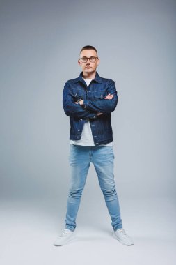 Zengin bir hayat yaşa. Olumlu duygular. Beyaz tişörtlü ve kot ceketli çekici bir adamın portresi. Kot koleksiyonundan erkek kıyafetleri.