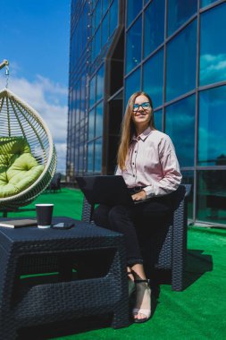 Bel ile laptop, yaz gününde eski şehir'in sokakta çalışan güzel kız, gözlük, beyaz gömlek ve mavi ceket giyiyor