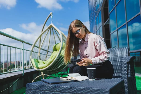 Genç mutlu bir kadın cep telefonuyla gülümsüyor ve konuşuyor, iş kadını bir kafede netbook ile masada dinlenirken not alıyor.