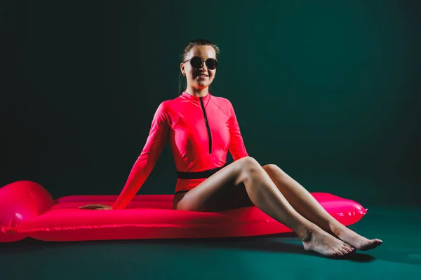 매력적 아름다운 여자가 선글라스를 분홍색 수영복을 스튜디오 배경에 고립된 팽창할 — 스톡 사진