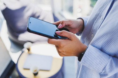 Siyah ekranlı modern bir cep telefonu bir kadının elinde, akıllı telefonları olan bir kadının elinde.