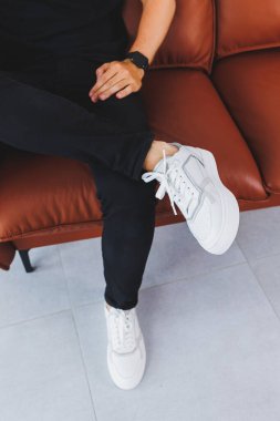 Beyaz deri spor ayakkabılı, yaz erkek ayakkabılı bir adam. Siyah kotlu adam