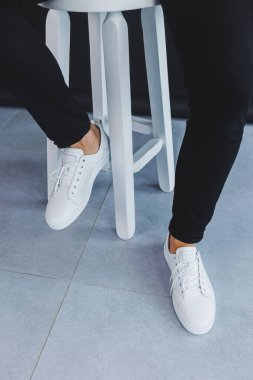 Beyaz deri spor ayakkabılı, yaz erkek ayakkabılı bir adam. Siyah kotlu adam