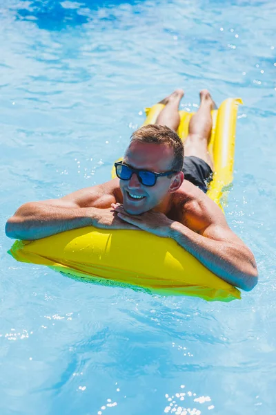 Attractive Young Man Sunglasses Shorts Relaxing Inflatable Yellow Mattress Pool — Stockfoto