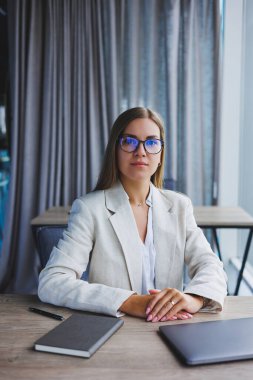 Successful young female manager in an elegant casual jacket and optical glasses, sits in the office at the workplace, an experienced woman with a modern laptop, working in the office