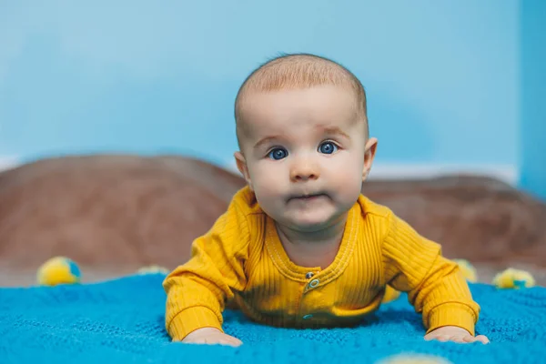 Egy Hónapos Kisgyermek Fekszik Ágyon Sárga Ruhában Gyermek Elkezdi Tartani — Stock Fotó