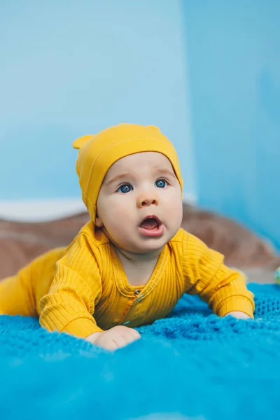 Egy Hónapos Kisgyermek Fekszik Ágyon Sárga Ruhában Gyermek Elkezdi Tartani — Stock Fotó
