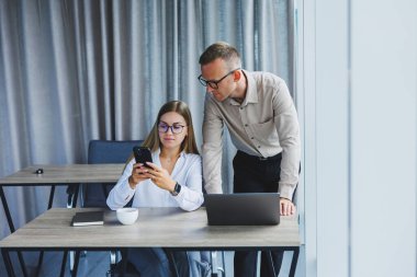 Erkek ve kadın meslektaşları dizüstü bilgisayarda ofiste çalışma süresi boyunca online formatta proje bilgileri üzerinde beyin fırtınası, genç başarılı ortaklar haber okuma ve netbook üzerinde fikir paylaşımı