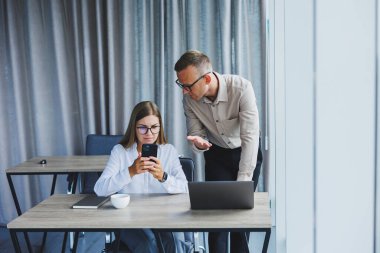 Erkek ve kadın meslektaşları dizüstü bilgisayarda ofiste çalışma süresi boyunca online formatta proje bilgileri üzerinde beyin fırtınası, genç başarılı ortaklar haber okuma ve netbook üzerinde fikir paylaşımı