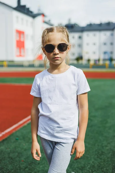 Little Blonde Girl Running Sports Field Smiling She Wearing Sunglasses — Fotografia de Stock