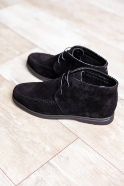 Black men's autumn boots, footwear material is genuine leather suede. Shoes isolated on the floor