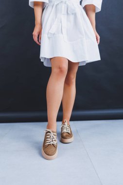 Women's brown leather sneakers on the legs close-up. Collection of summer women's shoes