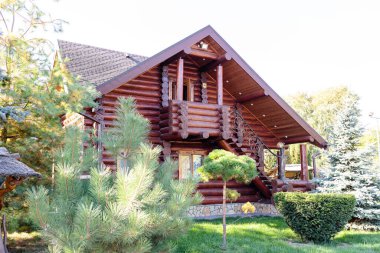 Beautiful wooden gazebo for outdoor recreation. Place in nature with a wooden house