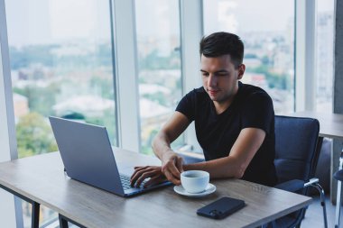 Happy man in optical glasses for vision correction looking for funny information in social networks using wireless connection on netbook, technology concept