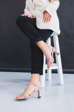 Yaz aylarında kadın bacakları, topuklu kahverengi parmak arası terlikler. Gerçek deriden yapılmış kadınlar için yaz koleksiyonu.