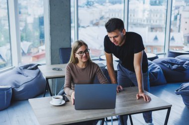 İki meslektaş bir dizüstü bilgisayarda çalışmayı tartışıyor. Ofiste iki meslektaş arasında dostça ilişkiler. Ofiste iş akışı