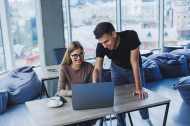 İki meslektaş bir dizüstü bilgisayarda çalışmayı tartışıyor. Ofiste iki meslektaş arasında dostça ilişkiler. Ofiste iş akışı
