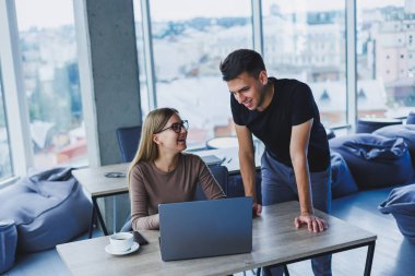 İki meslektaş bir dizüstü bilgisayarda çalışmayı tartışıyor. Ofiste iki meslektaş arasında dostça ilişkiler. Ofiste iş akışı