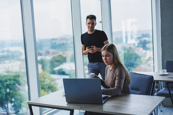 İki meslektaş bir dizüstü bilgisayarda çalışmayı tartışıyor. Ofiste iki meslektaş arasında dostça ilişkiler. Ofiste iş akışı