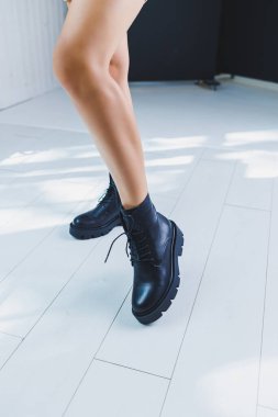 Siyah kadın botlarına yakın çekim. Gerçek deriden yapılmış siyah çizmeler. Sıcak çizmeli bir kadının bacaklarının yakın plan fotoğrafı.