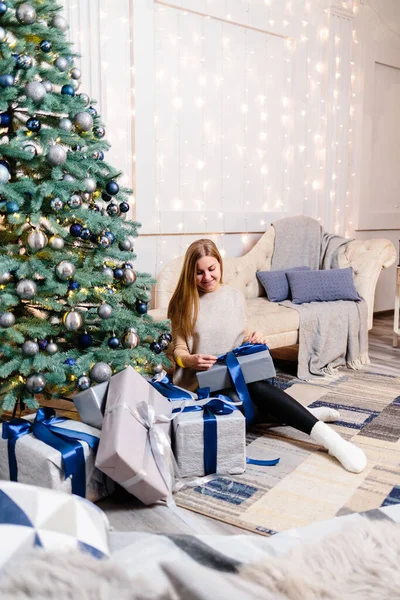 快乐的年轻女人 带着礼物躺在圣诞树旁 沙发上的白色银色背景圣诞快乐 新年快乐 大气瞬间 — 图库照片