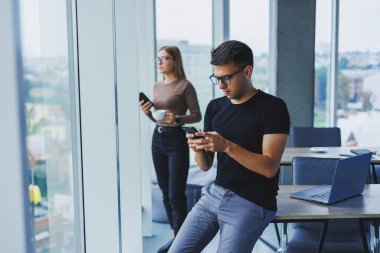 Ellerinde telefonla mutlu bir işadamı, masasında bir öğrenci, bir kafede bir masa, pozitif bir sakin insan, rahatlama, bir hayal, bilgisayardan uzaklaşma, stres hissetme.